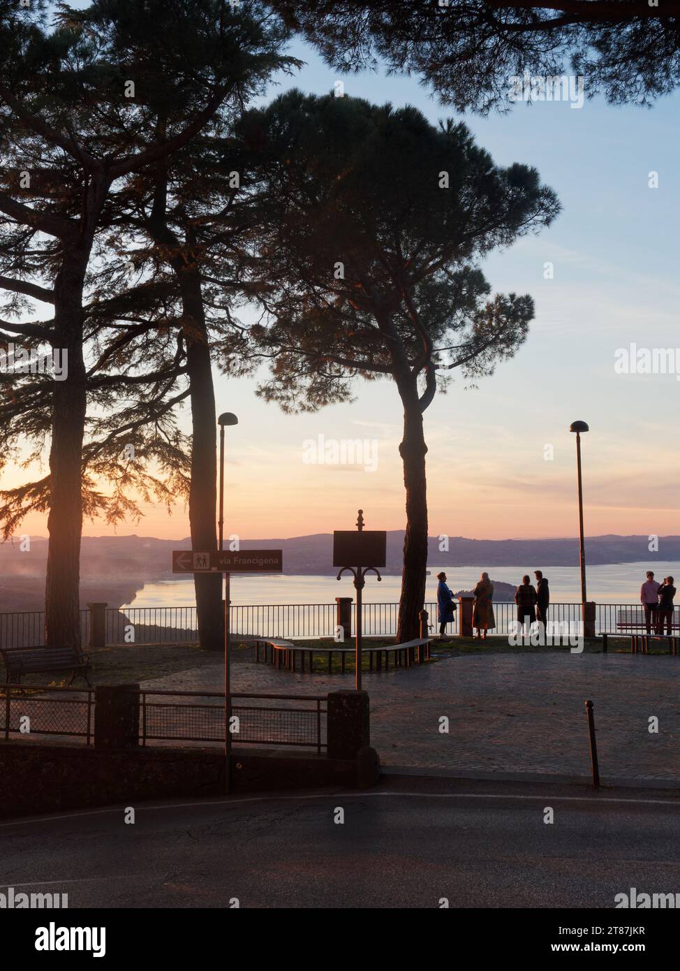 Die Menschen genießen den ruhigen Herbst und den Sonnenuntergang über dem Bolsenasee von einem Aussichtspunkt in Montefiascone, Region Latium, Italien. November 2023 Stockfoto