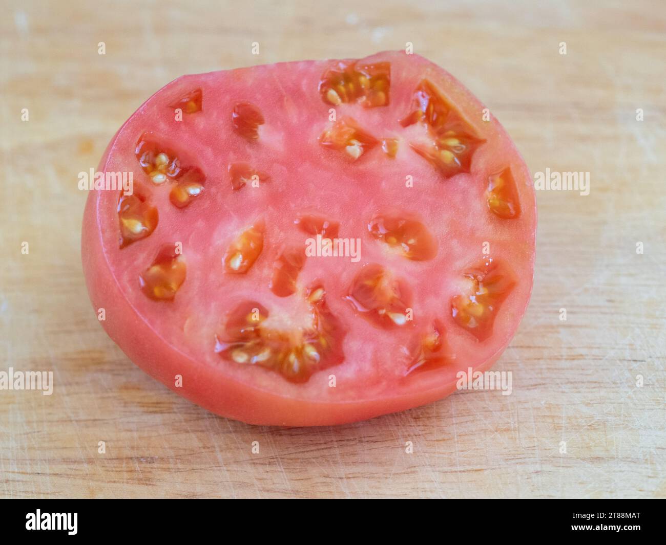 Frische Produkte, saftige rote Tomaten in Scheiben mit Fleisch und Samen, die in einem australischen Gemüsegarten angebaut werden Stockfoto