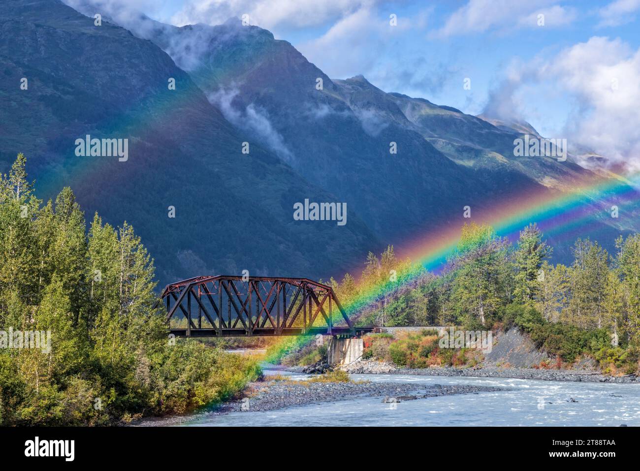 Das Ende (oder der Beginn) eines Doppelregenbogens auf einer Alaska Railroad Brücke über den Placer River in der Nähe des Spencer Glacier im Chugach National Forest, Alaska. Stockfoto