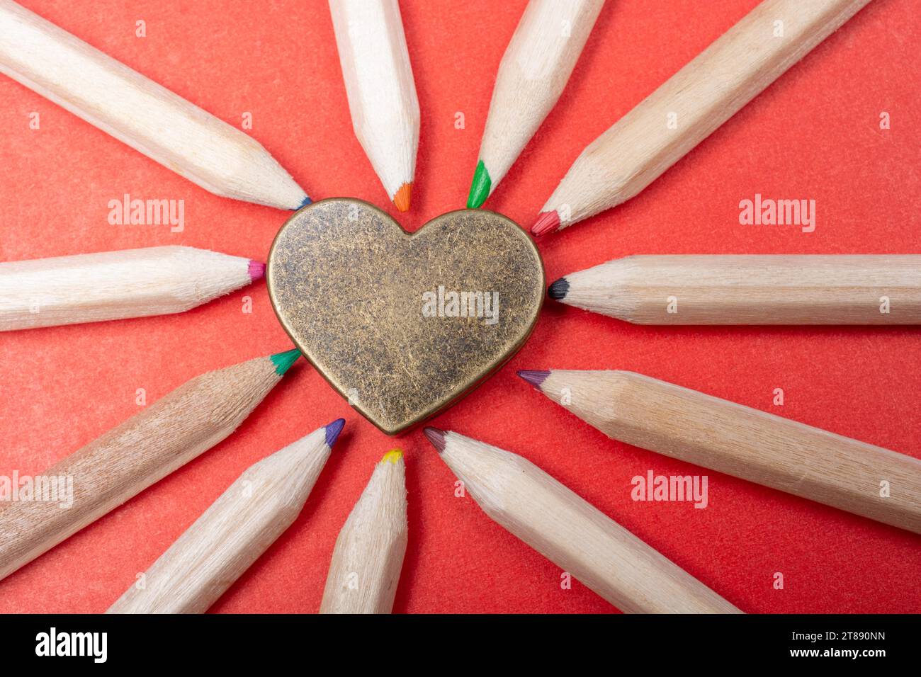 Herz mit geschärften mehrfarbigen Bleistiften ausgelegt Stockfoto