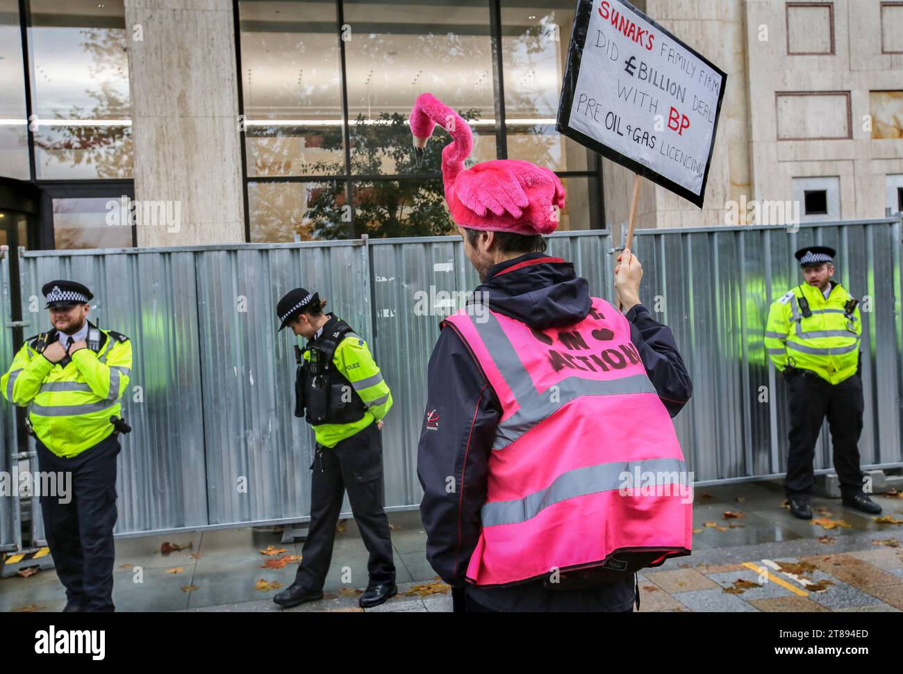 Ein Demonstrant trägt einen Flamingohut und hält ein Plakat, das Rishi Sunaks Familie beschuldigt, einen Milliardenvertrag mit BP vor dem stark geschützten Shell-Hauptquartier zu unterzeichnen. Stoppen Sie einfach den ölmarsch durch London, um die Notwendigkeit hervorzuheben, die Art und Weise zu ändern, in der wir von Öl und Gas als Energie abhängig sind. Sie argumentieren, dass die Zeit für den Planeten abläuft und eine sofortige Abkehr von fossilen Brennstoffen notwendig ist. Sie sagen, dass die Regierung friedliche Demonstranten inhaftiert und die wahren Verbrecher schützt und sie mit der Genehmigung von mehr als 100 neuen Öl- und Gasprojekten belohnt. Stockfoto