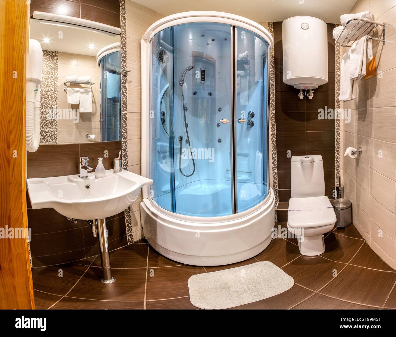 Hotelbadezimmer mit Hydromassage-Duschkabine, Wasserkocher und Spiegel Stockfoto