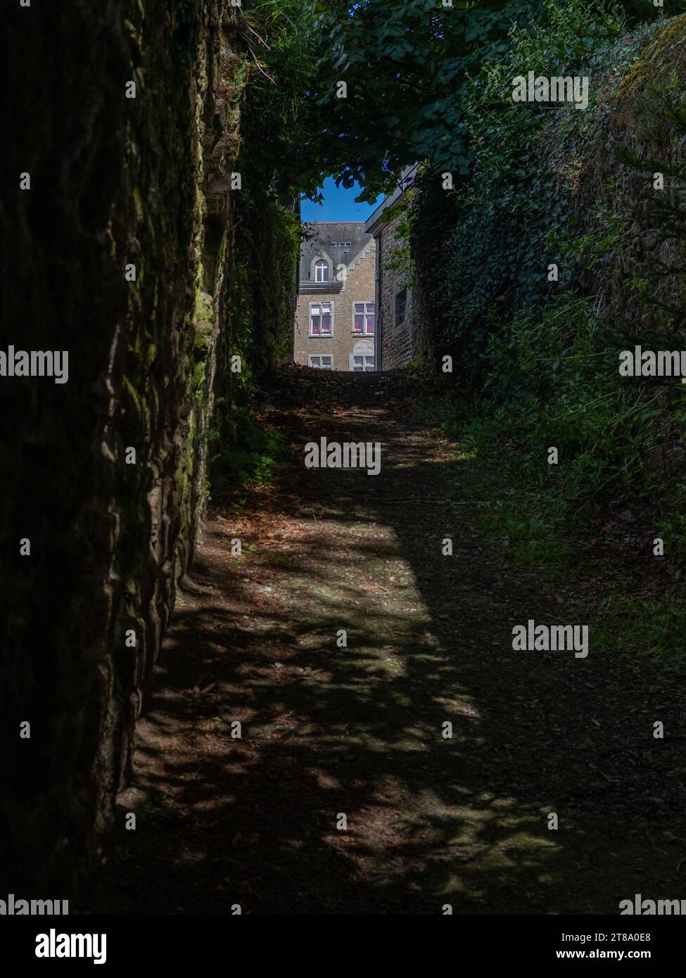 Eine enge, dunkle Gasse in Quintin, Bretagne, Frankreich, an einem sonnigen Sommertag ohne Menschen Stockfoto