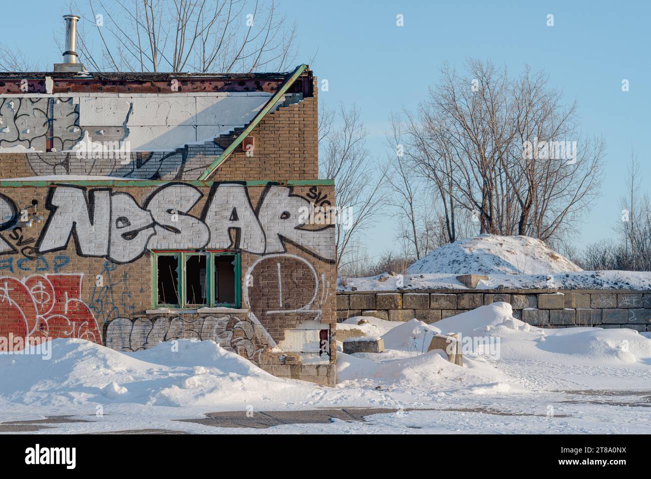 Ein verlassenes Industriegebäude mit Graffiti an einem sonnigen Wintertag in der Nähe von Montreal, Quebec, Kanada Stockfoto