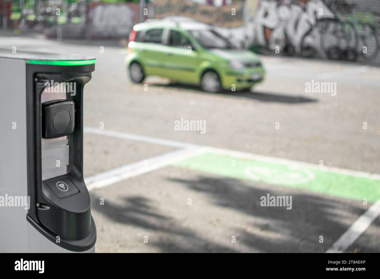 Ladestation für Elektroautos mit verschwommenem Hintergrund des Autos dahinter Stockfoto