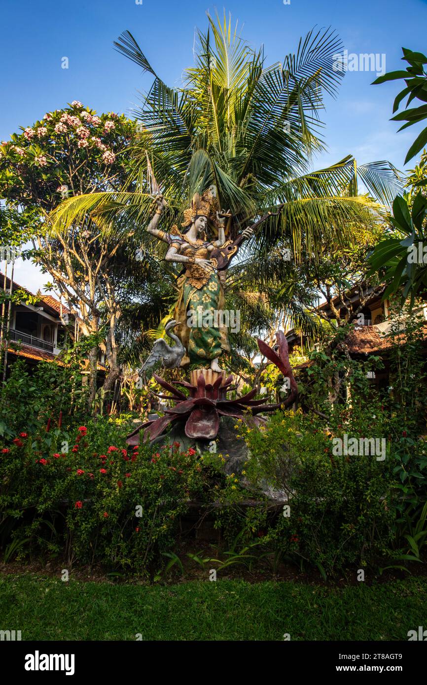 Parkbereich mit tropischen Pflanzen und traditionellen Statuen des hinduistischen Glaubens und zur Dekoration. Tropisches Inselleben als Tourist in Bali Indonesien Stockfoto