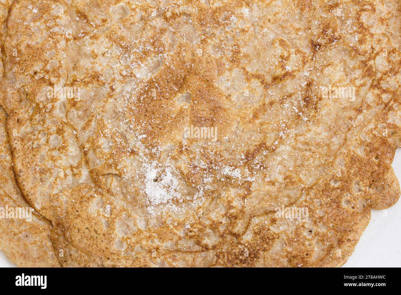 Blick von oben auf eine Nahaufnahme spanischer Crepes mit Süßpulver. Traditionelles Dessert. Stockfoto