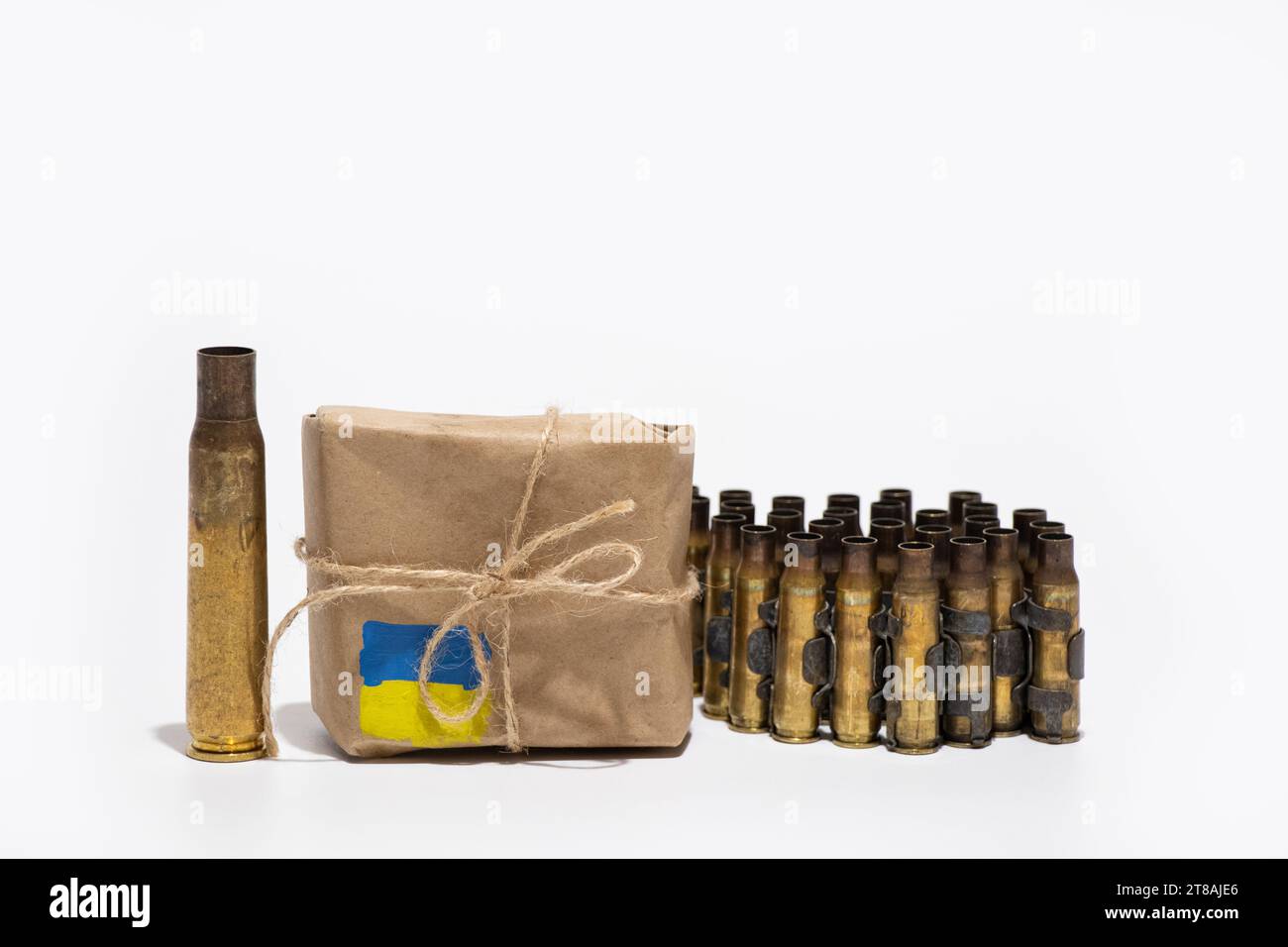 Neben einer Box, auf der die Flagge der Ukraine gemalt ist, stehen ein automatisches Gewehrgehäuse und ein Band mit Kugellandschaften, humanitäre Hilfe in Form o Stockfoto