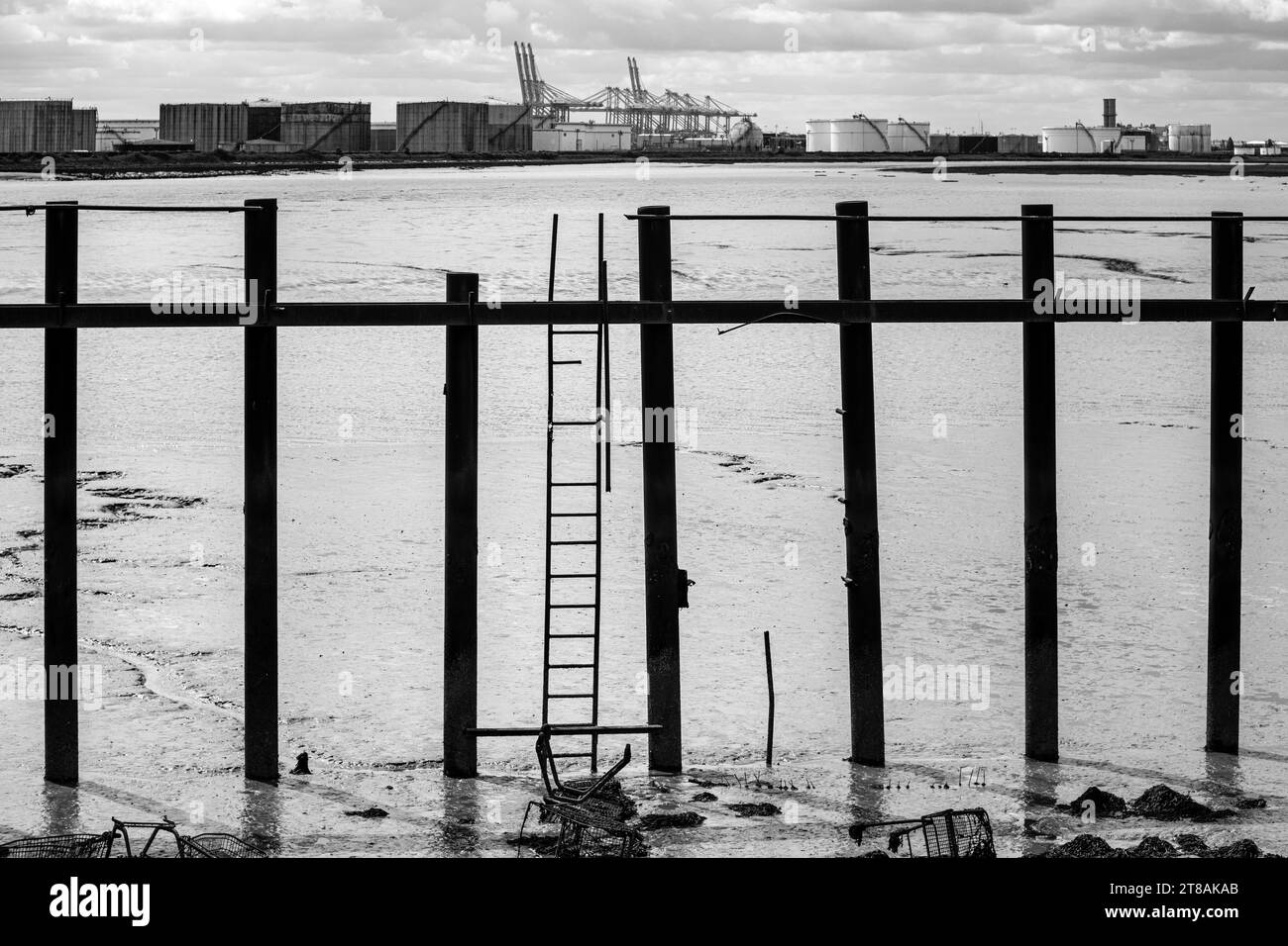 Blick von Canvey Island in die Coryton-Ölraffinerie. Wattgebiete des Holehaven Creek, Öllagercontainer und DP World Gateway Black and White. Stockfoto