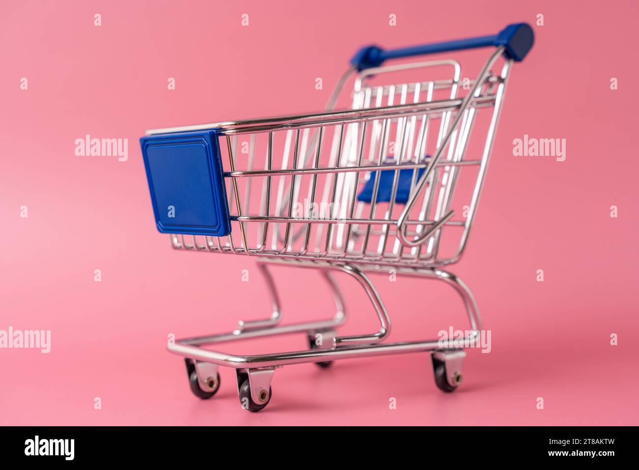 Augsburg, Bayern, Deutschland - 15. November 2023: Miniatur-Einkaufswagen vor pinkem Hintergrund *** Miniatur-Einkaufswagen vor pinkem Hintergrund Credit: Imago/Alamy Live News Stockfoto