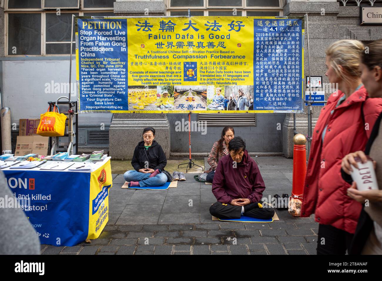 Menschen praktizieren Falun Gong oder Falun Dafa Meditation auf der Straße in china Town, London, als Protest gegen den Organraub in China. Stockfoto