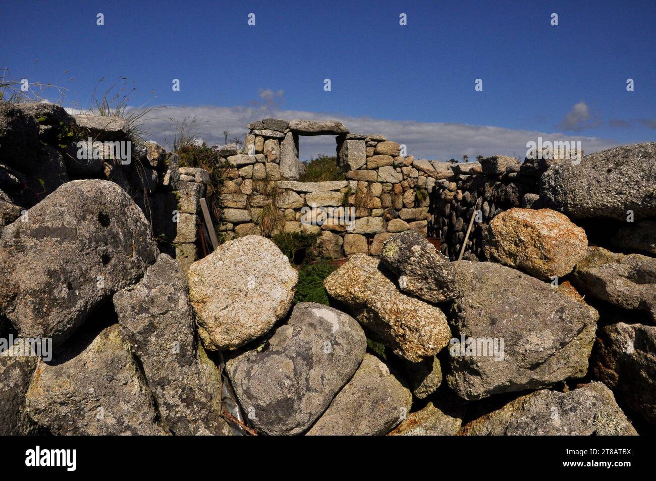 Die Ruine der Granitsteinhütte auf der Insel St. Martins auf den Scilly-Inseln zeigt den ruhigen, sanften Lebensstil der Inseln. Der hellblaue Himmel mit Stockfoto