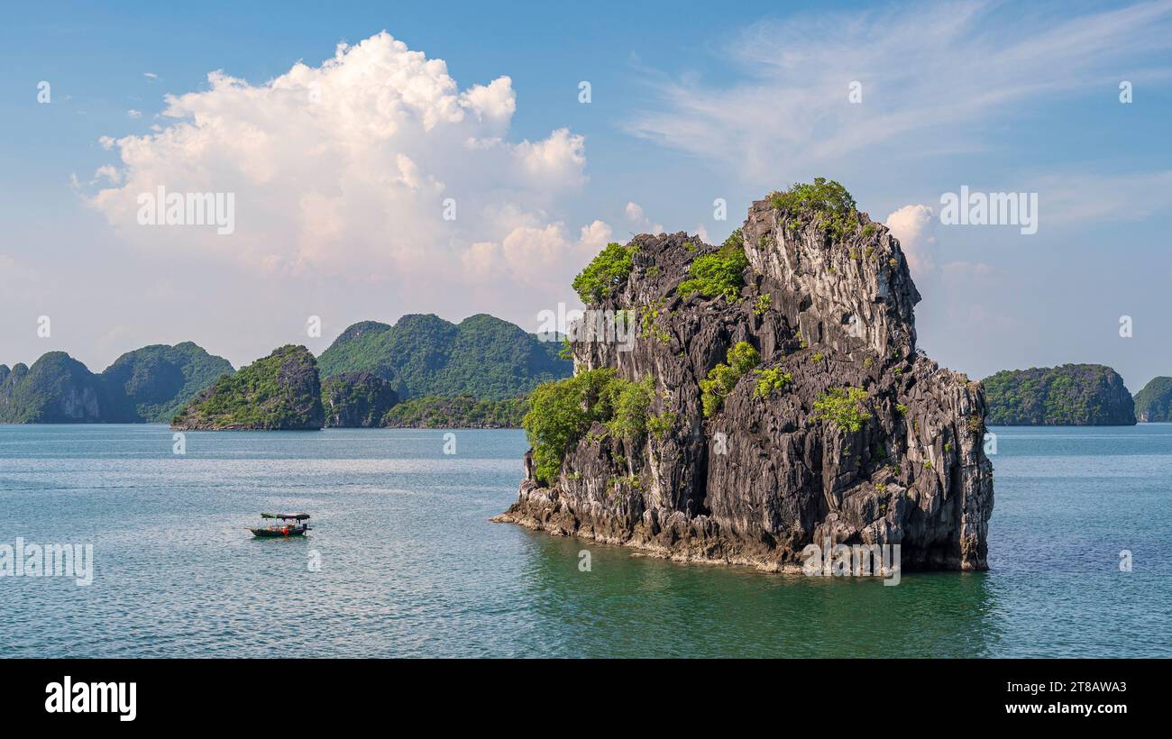 Kleine Fischerboote, in der spektakulären Landschaft der Ha Long Bay, Vietnam. Eines der modernen Naturwunder der Welt. Stockfoto