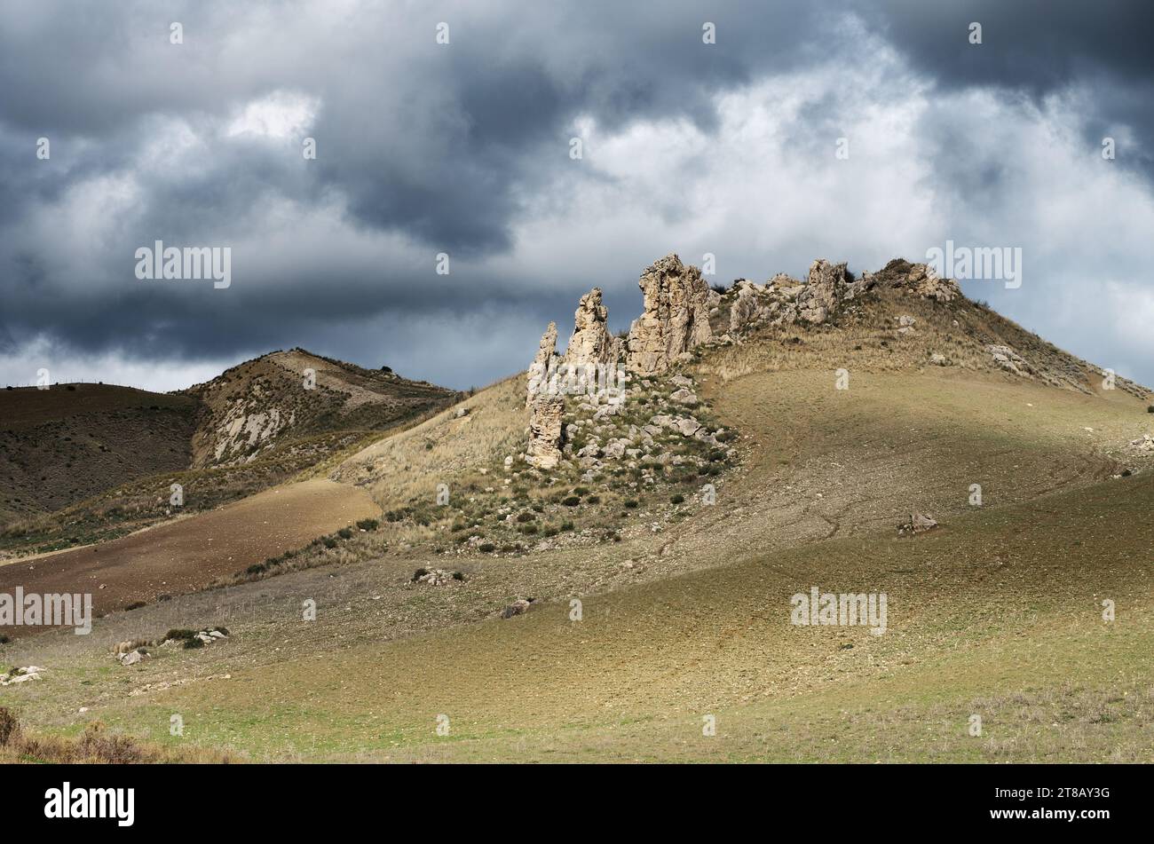 Landschaft für dramatische Wolken auf einem Hügel mit Felsformationen in der Landschaft von Sizilien, Italien Stockfoto