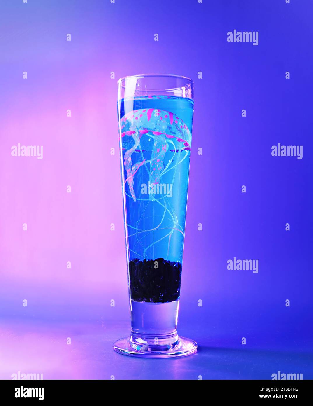 Elektrische Qualle: Eine neonrosa und blaue Medusae in einem Bierglas - Marine Life and Aquarium Event Concept Stockfoto