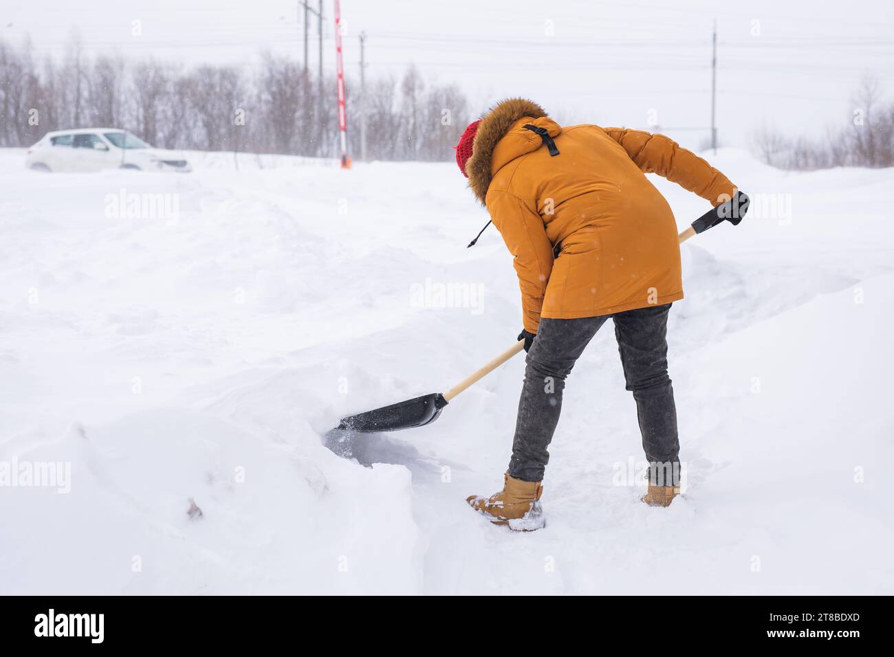Mann, der Schnee vom Bürgersteig reinigt und Schneeschaufel benutzt. Wintersaison Stockfoto