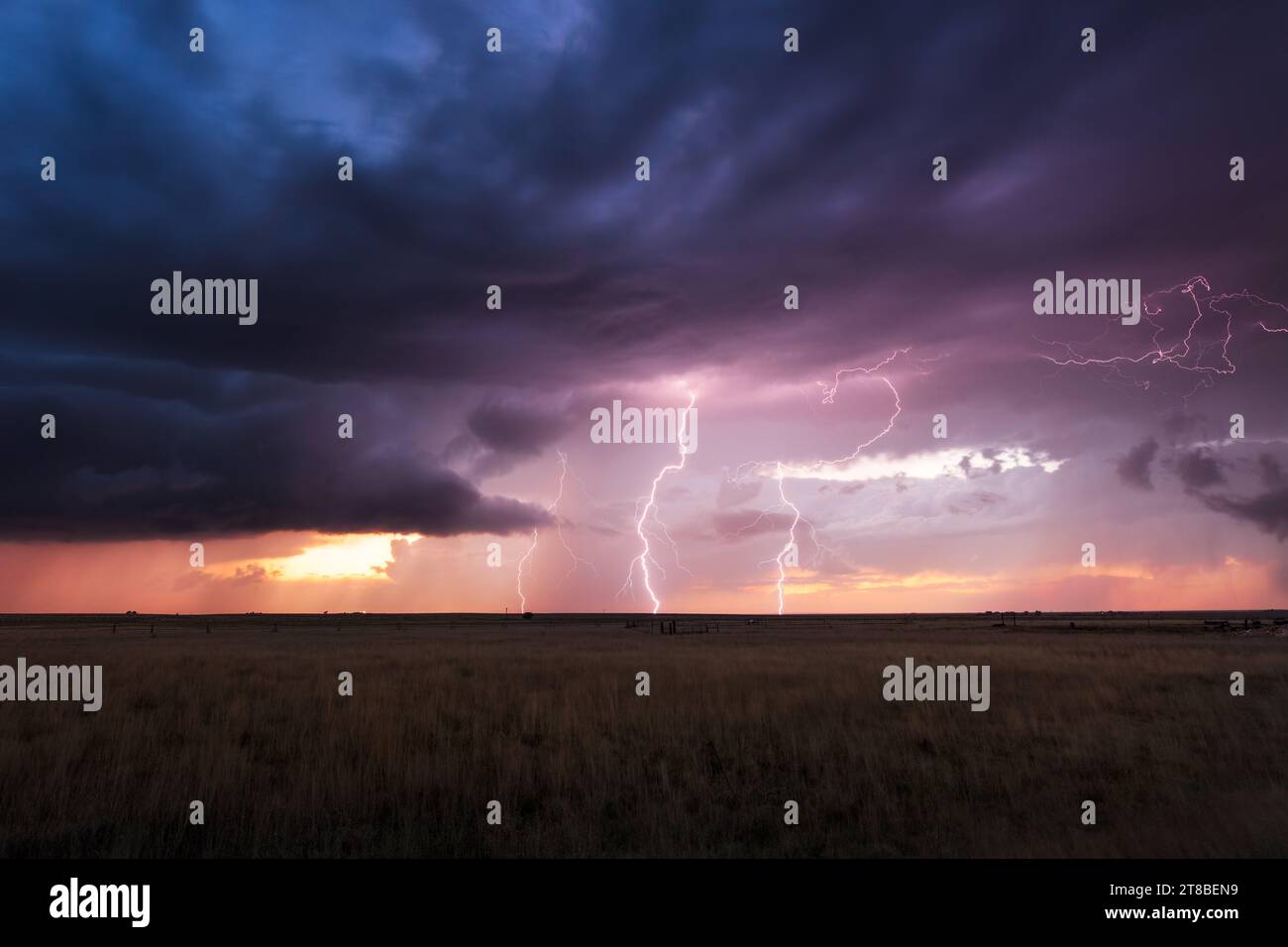 Ein unheilvoller, stürmischer Himmel mit Blitzen bei Sonnenuntergang in der Nähe von House, New Mexico Stockfoto