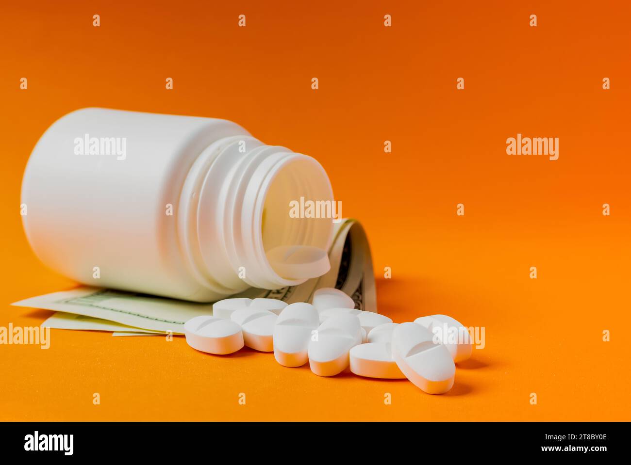 Das Konzept der teuren Medizin, dargestellt mit Dollar und weißen Pillen. Stockfoto