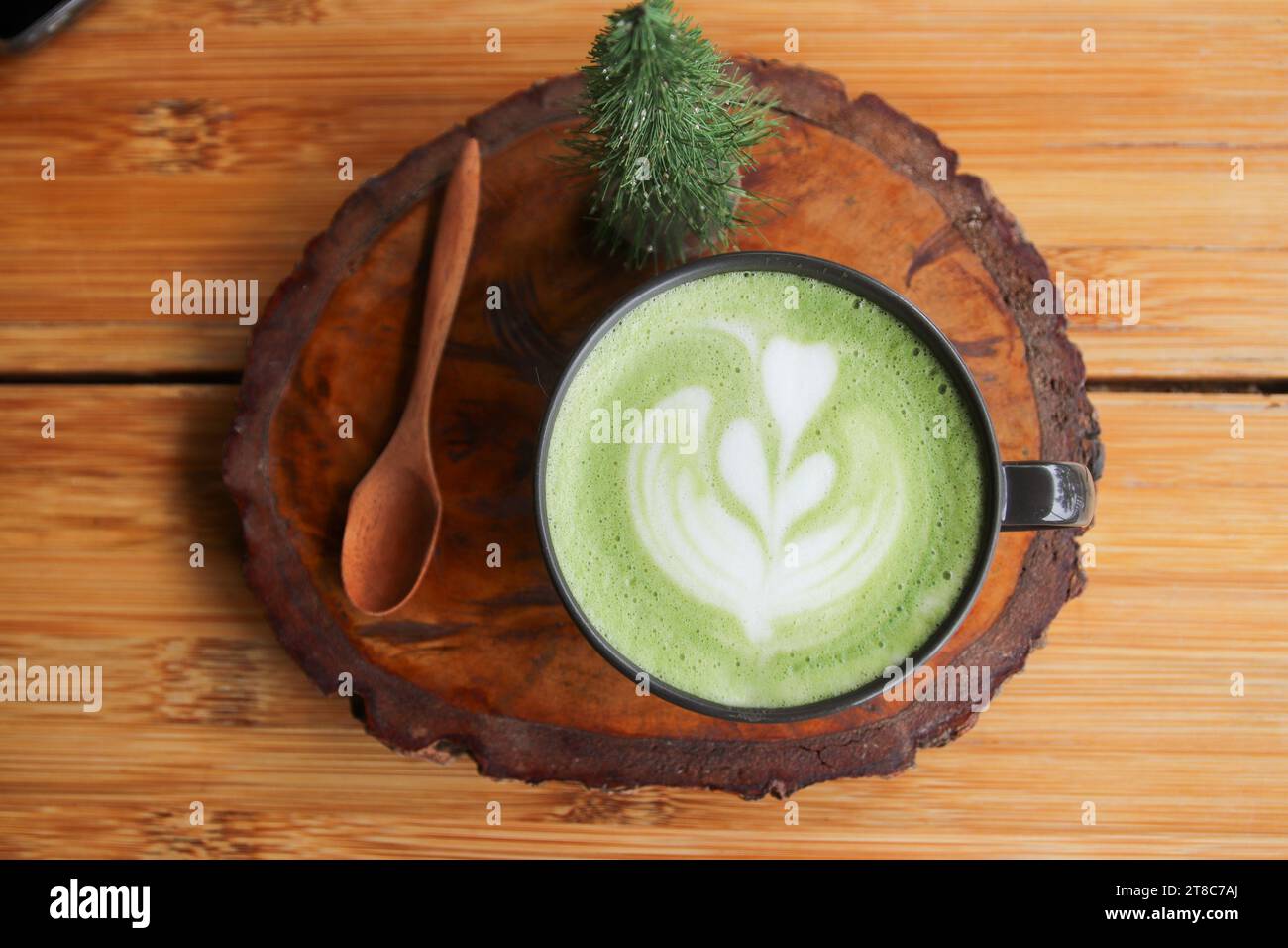 Tasse grüner Milchtee auf einem Holzständer Stockfoto