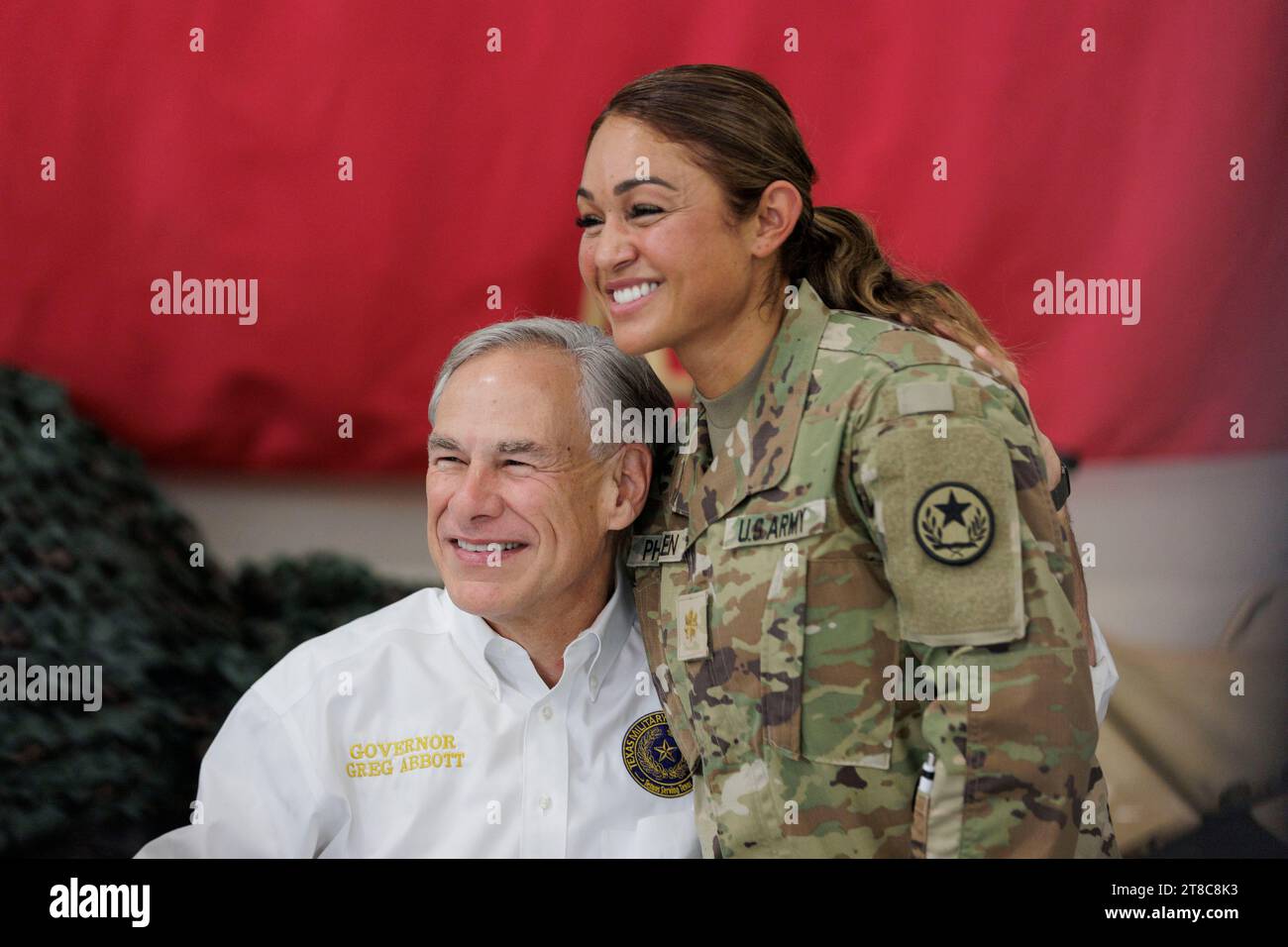 Edinburg, Texas USA, 19. November 2023: Texanischer Gouverneur GREG ABBOTT posiert mit einem Mitglied der Texas National Guard am South Texas International Airport. Der ehemalige Präsident Trump (nicht im Bild) und Abbott servierten Mahlzeiten an die Truppen der texanischen Nationalgarde und des texanischen Ministeriums für öffentliche Sicherheit (DPS), die während des Erntedankfestes an der Grenze zwischen den USA und Mexiko stationiert sind. Foto: Michael Gonzalez/Pool Stockfoto