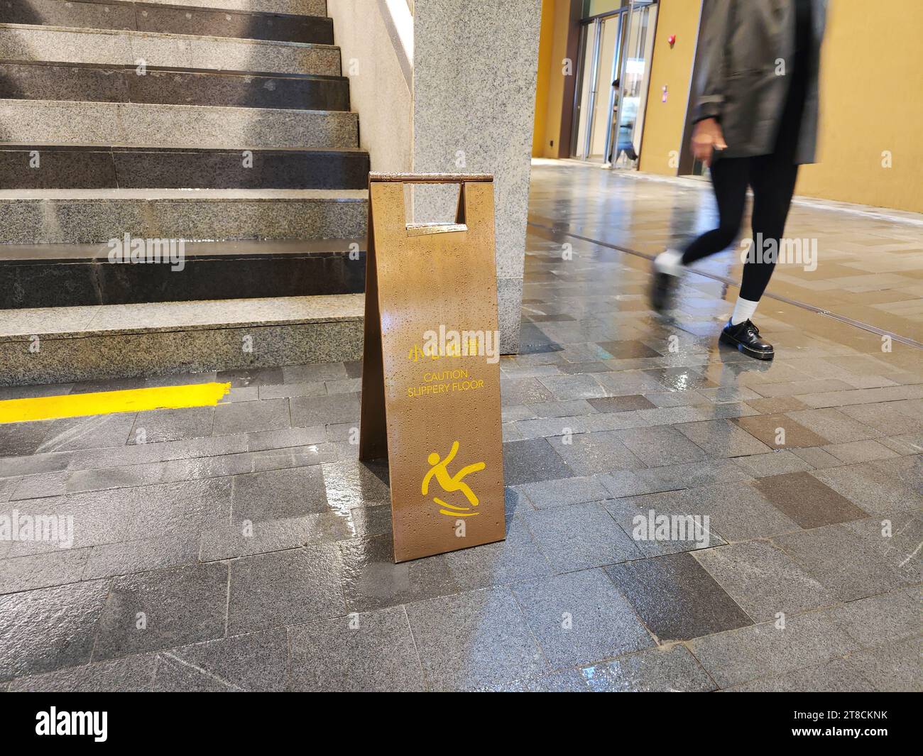 Schild „Vorsicht rutschiger Boden“ auf nassem Boden Stockfoto