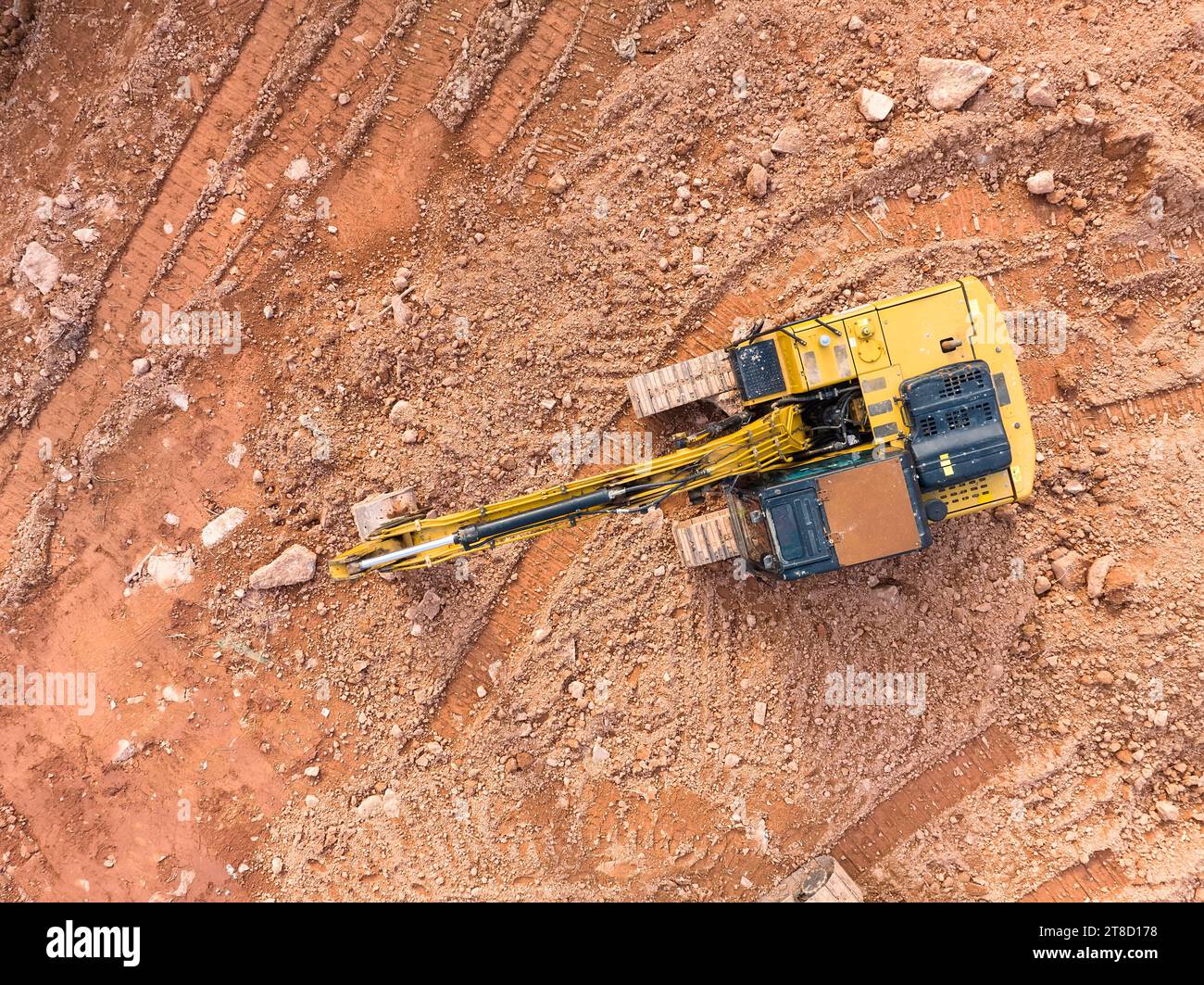 Bagger auf Raupen in der Gründungsgrube beim Bau des Gebäudefundaments, Graben. Draufsicht aus der Luft Stockfoto
