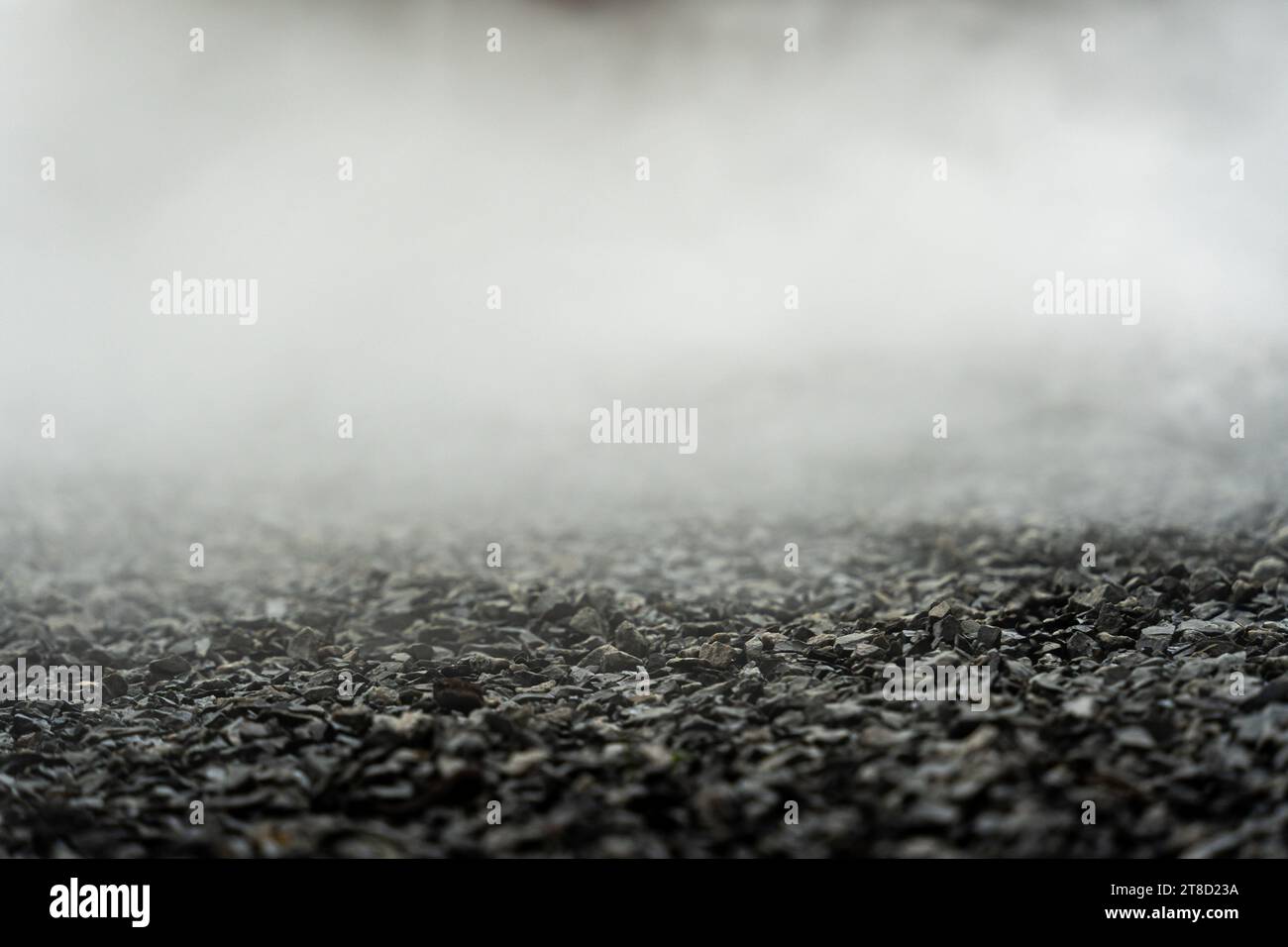Kiesboden mit Nebel oder Nebel. Helle, dunkle und graue abstrakte Kies-Textur für Displayprodukte. Selektiver Fokus Stockfoto