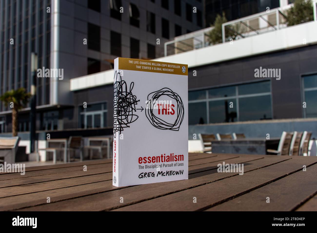 Greg McKeown's Essentialism: The disziplined Pursuit of less Book on a Holztisch. Stockfoto