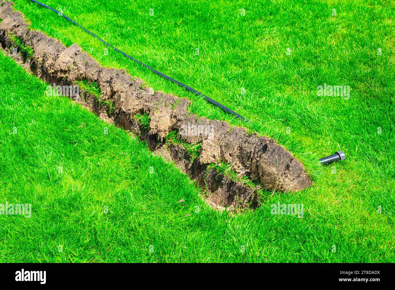 Installation eines ausfahrbaren Sprinklers im Rasen, Nahaufnahme. Integration Der Grasbewässerung Stockfoto