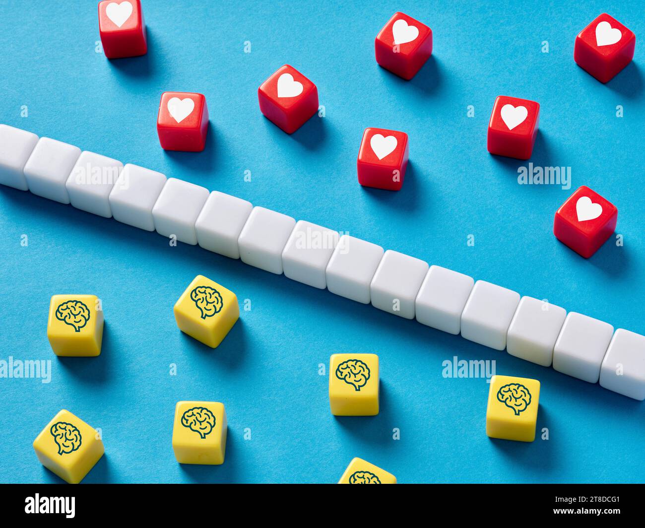 Emotion versus Logik. Logische oder emotionale Entscheidungsfindung oder Denken. Menschliche Gehirn- und Herzsymbole auf bunten Würfeln. Stockfoto
