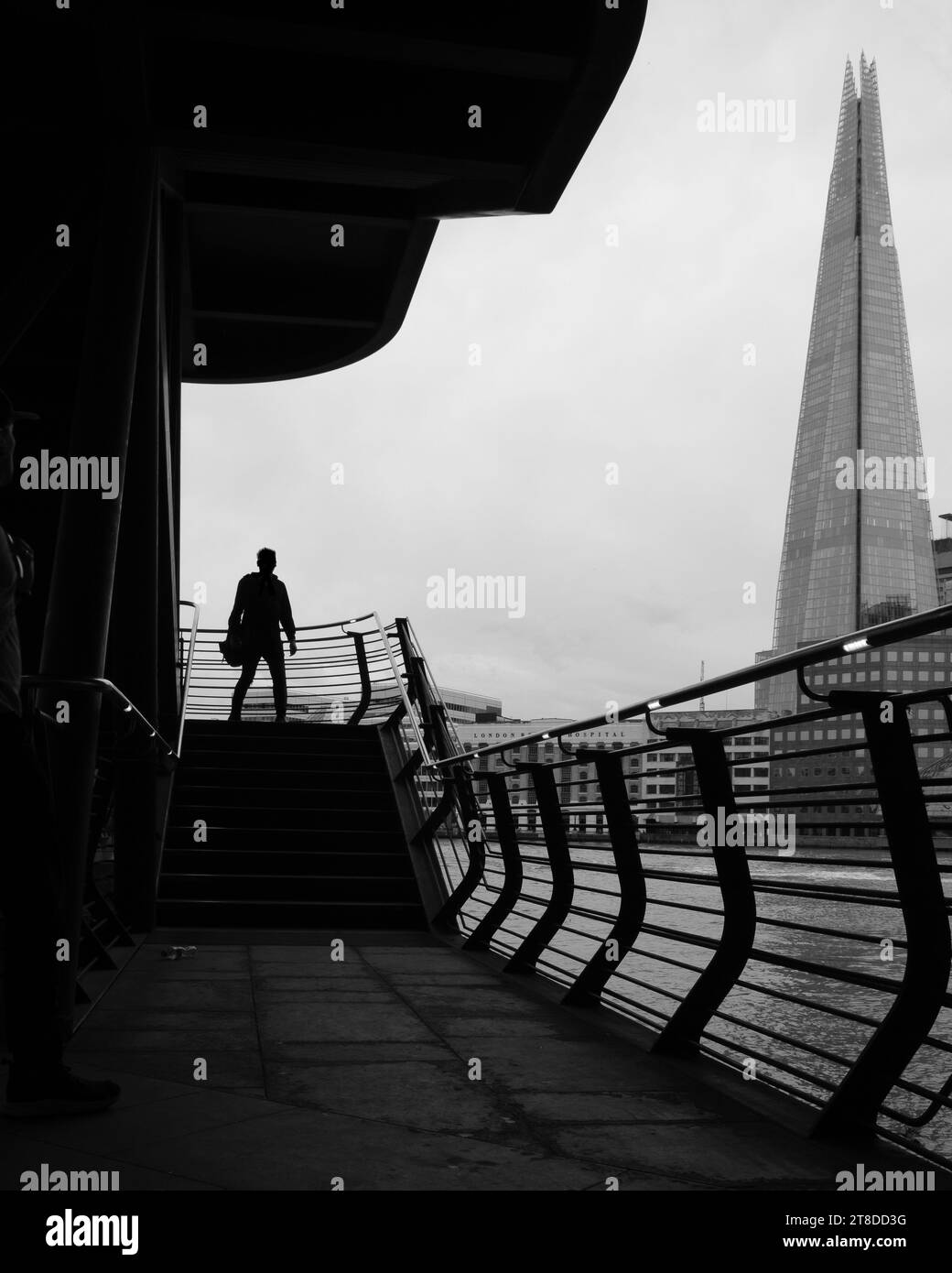 Schwarz-weiß-Bild der Silhouette eines Mannes auf der Außentreppe mit Londoner Ikone, The Shard im Hintergrund. Stockfoto