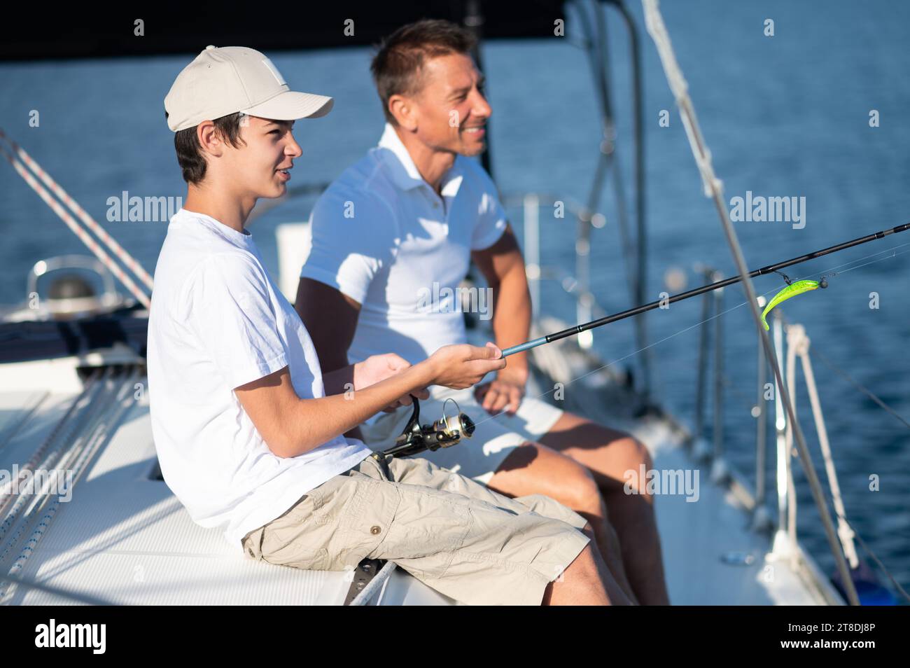 Dad und Sohn verbringen Zeit zusammen auf der Yacht und fisihen Stockfoto