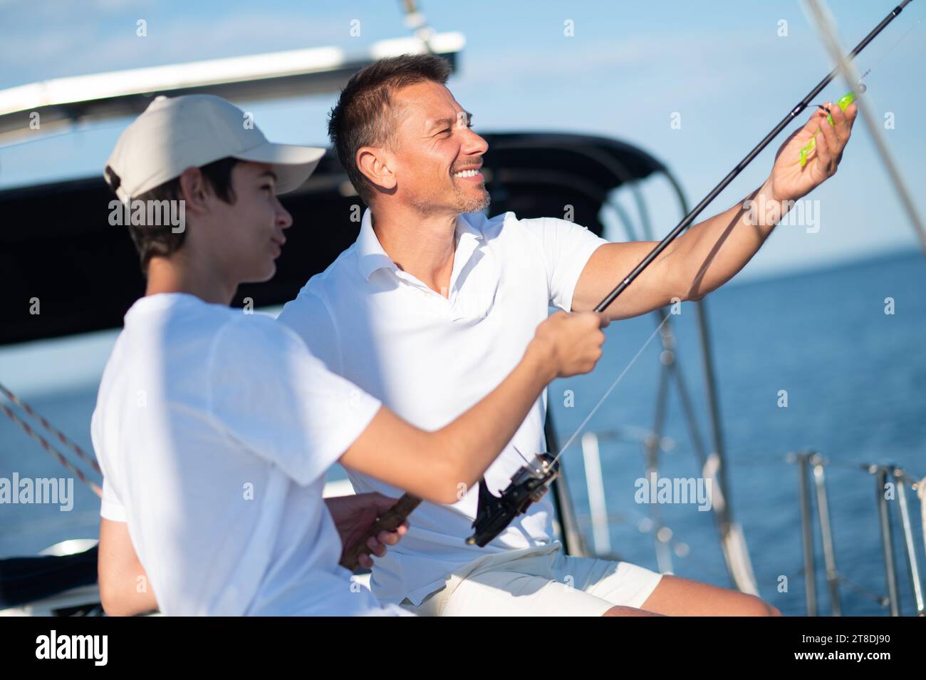 Dad und Sohn verbringen Zeit zusammen auf der Yacht und fisihen Stockfoto