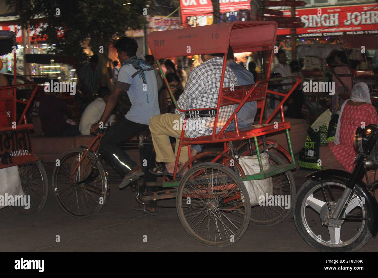 Ein unbekannter Rikscha-Abzieher, der nachts auf den Straßen des Chandni Chowk Markts in Neu-Delhi, Indien, am 14. November 2023 arbeitete. Stockfoto