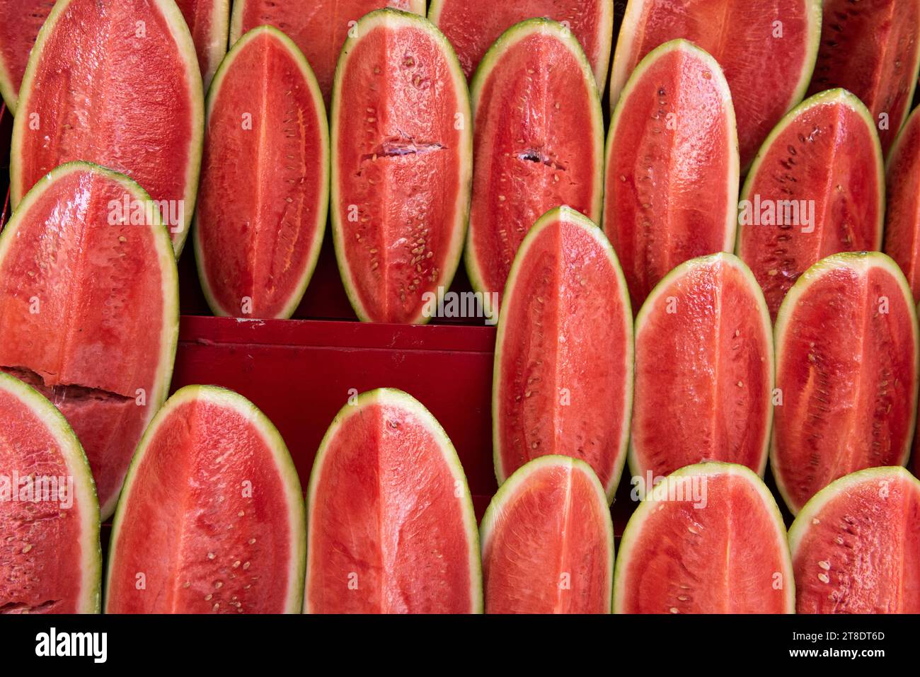 Reihen geschnittener, reifer, roter Wassermelonen in Cellophan auf einem Markt im Freien in Tel Aviv, Israel. Stockfoto