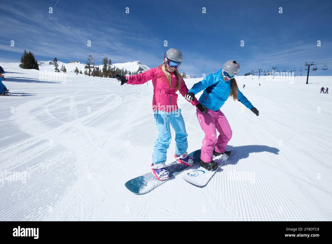 Zwei weibliche Snowboarderinnen, die Spaß beim Snowboarden haben. Stockfoto