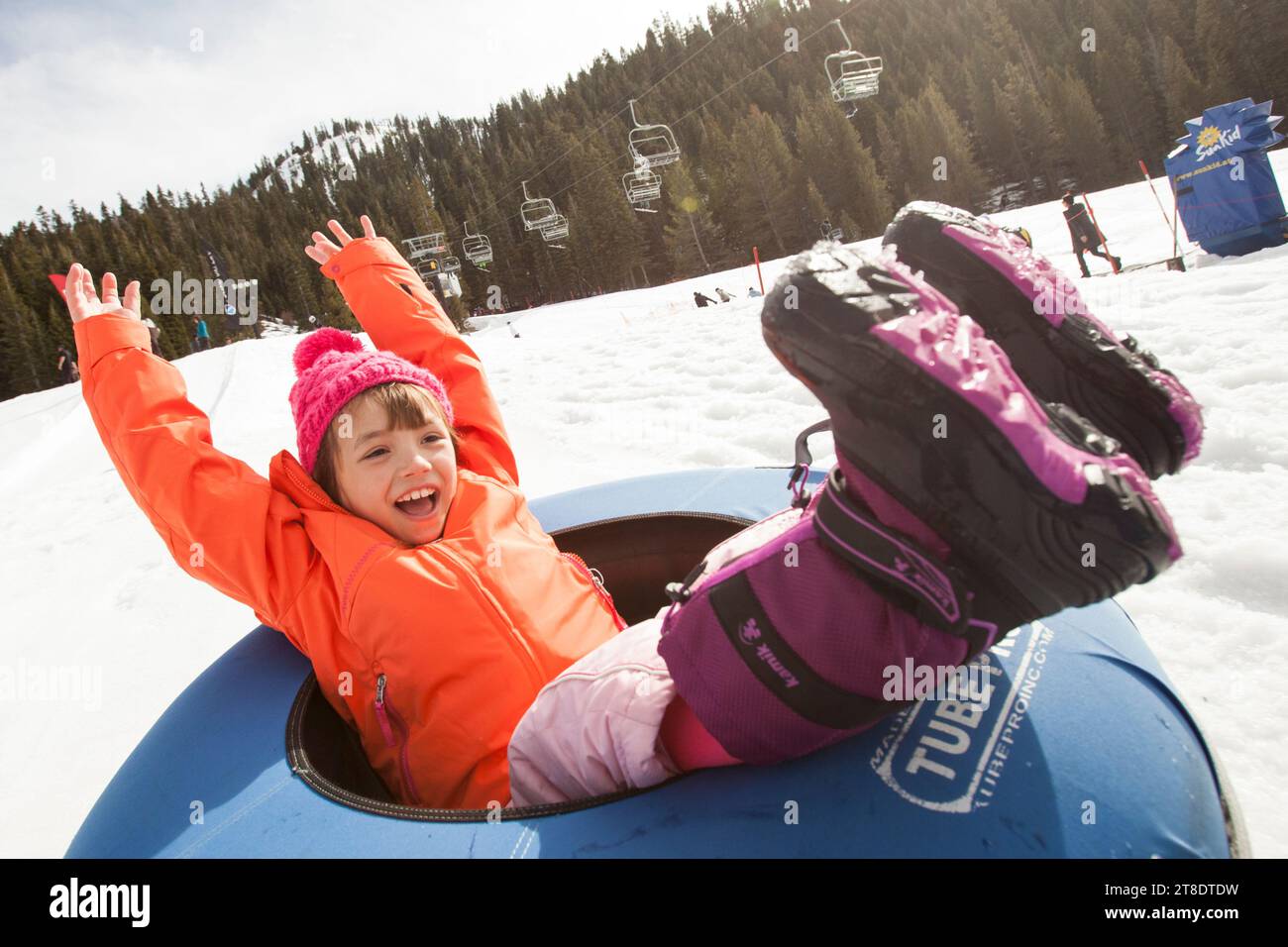Ein junges Mädchen, das auf Schnee tuscht und Spaß hat. Stockfoto