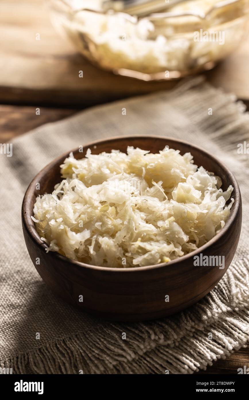 Fermentierter Kohl in einer Schüssel auf hölzernem Schneidebrett. Stockfoto