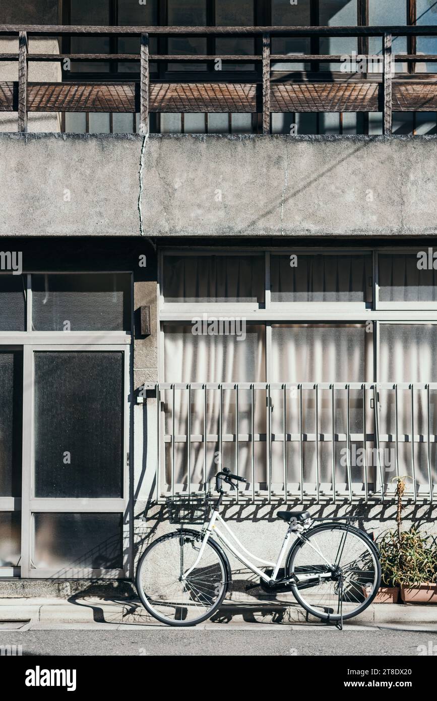 Weißer Fahrradparkplatz vor dem klassischen japanischen Gebäude Stockfoto