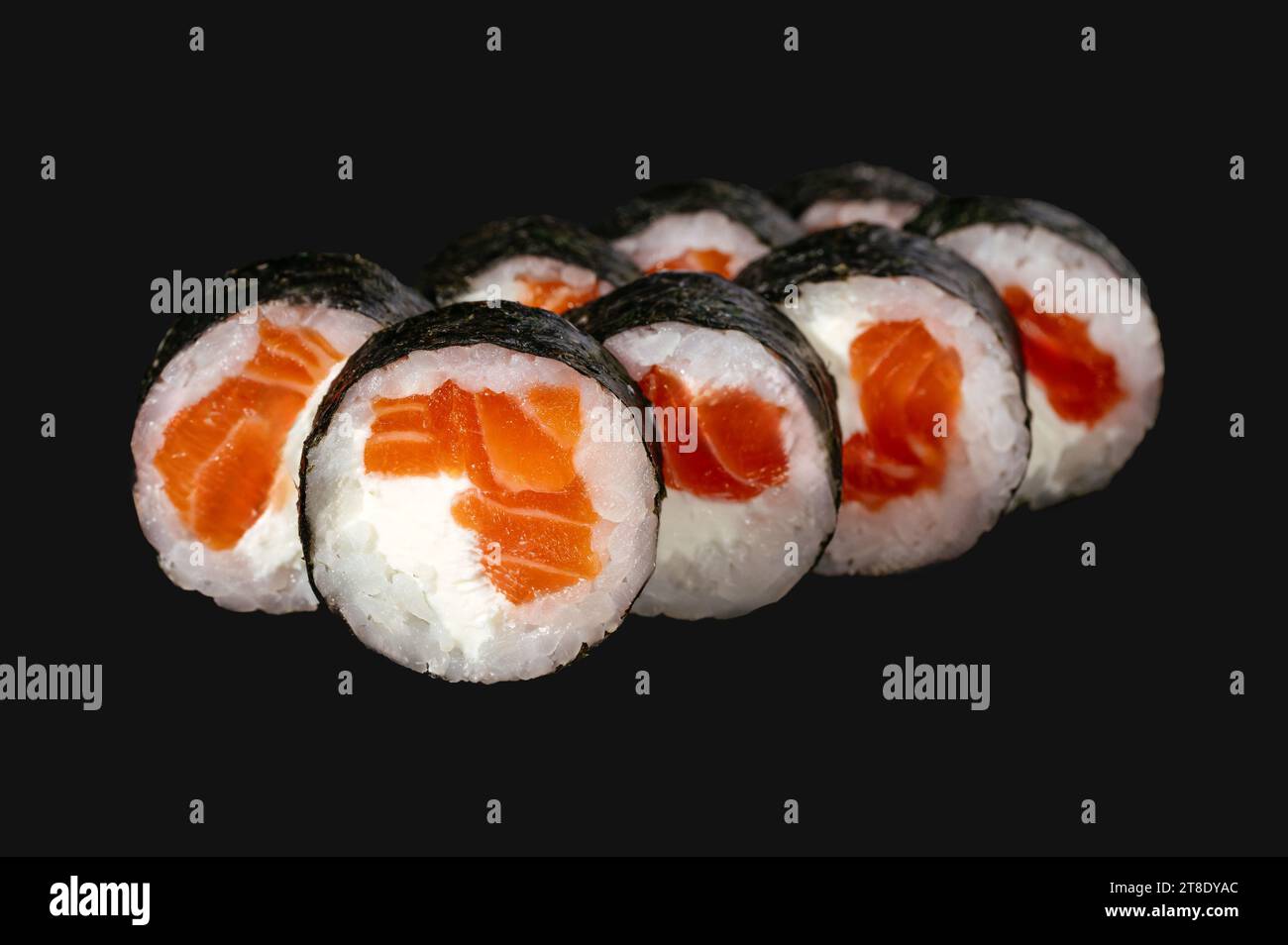Sushi-Rolle mit Lachs auf schwarzem Hintergrund. Stockfoto