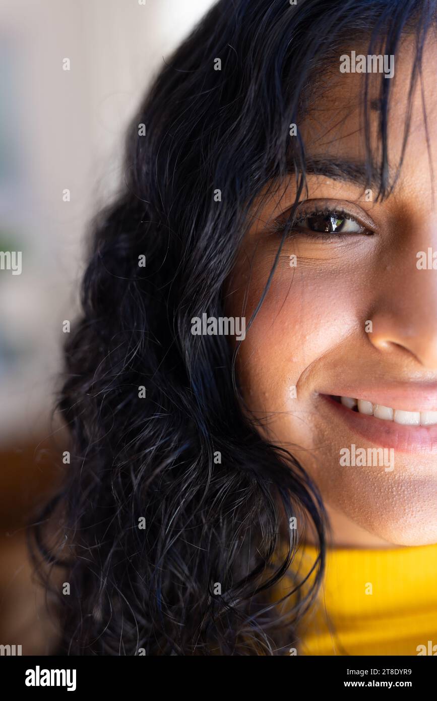 Porträt einer glücklichen birassischen weiblichen Teenagerin mit langen schwarzen Haaren zu Hause Stockfoto