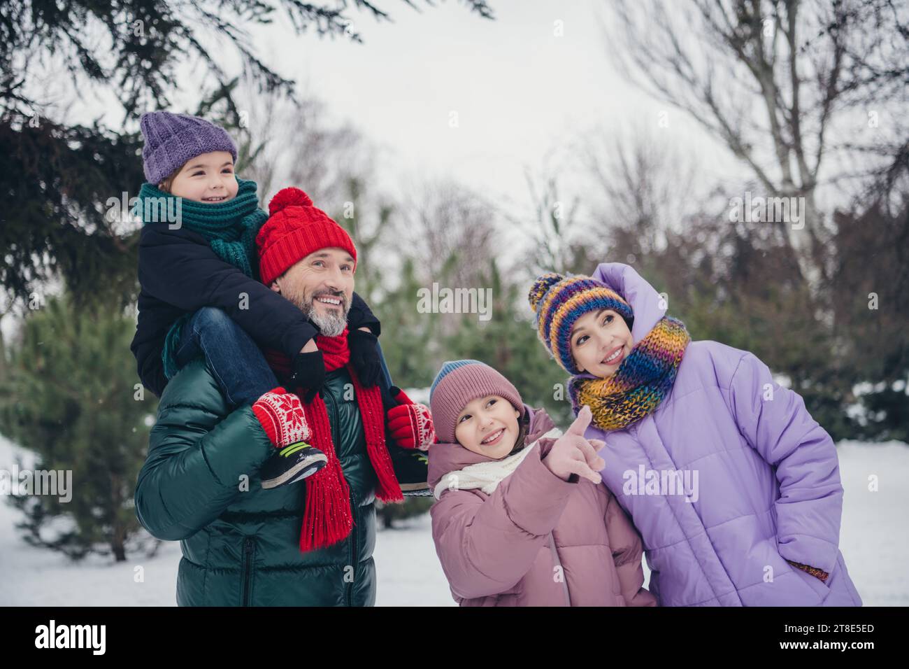 Foto von einem freundlichen süßen kleinen Kind Ehefrau gekleidete Mäntel, die zusammen den Nordpol des weihnachtsmanns im Freien im städtischen Waldpark besuchen Stockfoto
