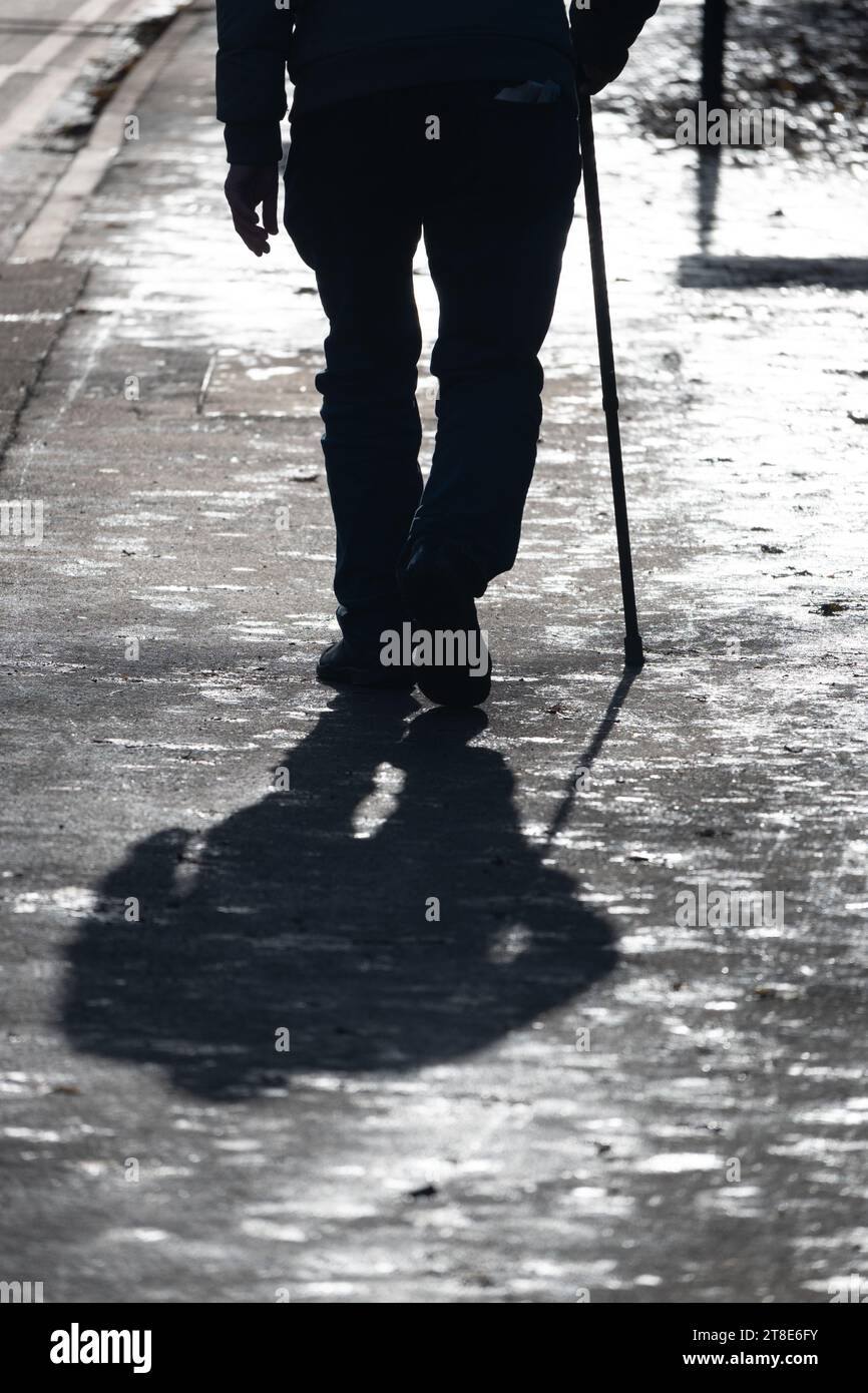 Älterer Mann, der mit einem Stock läuft, UK Stockfoto