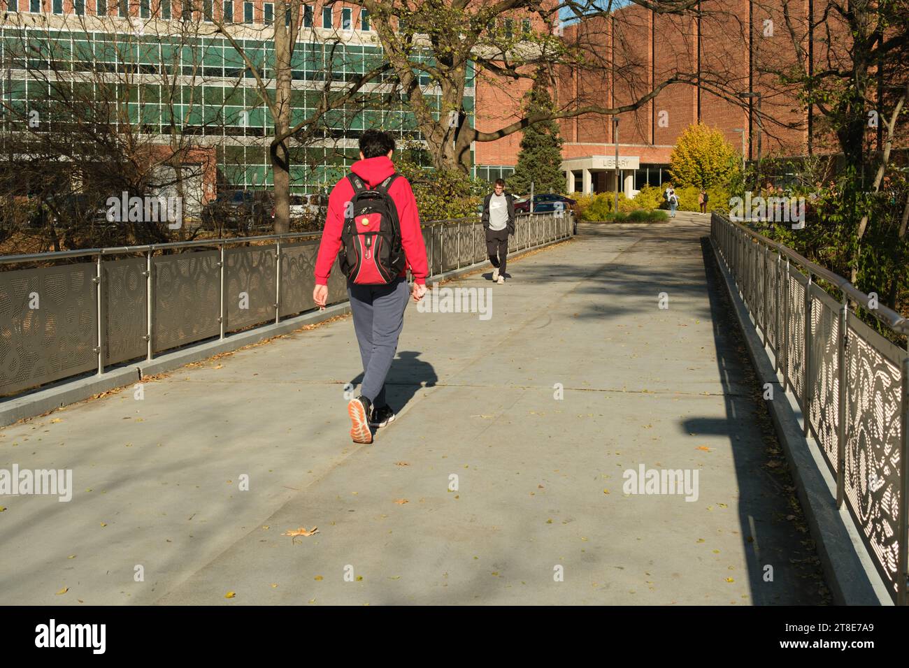 Studenten der Michigan State University gehen über eine Brücke über den Red Cedar River. Stockfoto