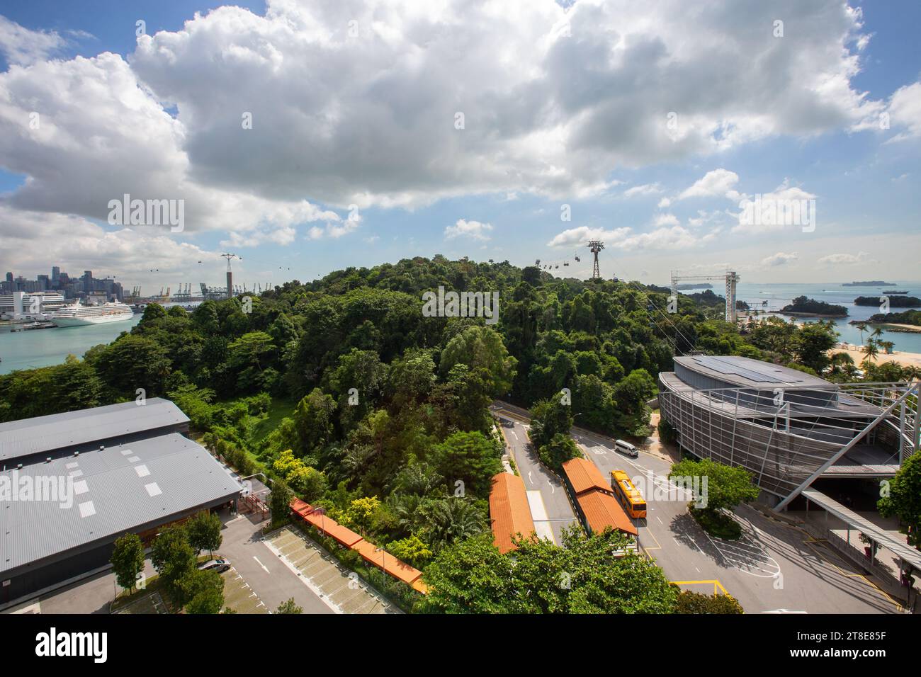 Blick aus der Vogelperspektive auf die Insel Sentosa, teilweise bedeckt mit grüner Vegetation, Strand und Seilbahnen, Singapur. Stockfoto