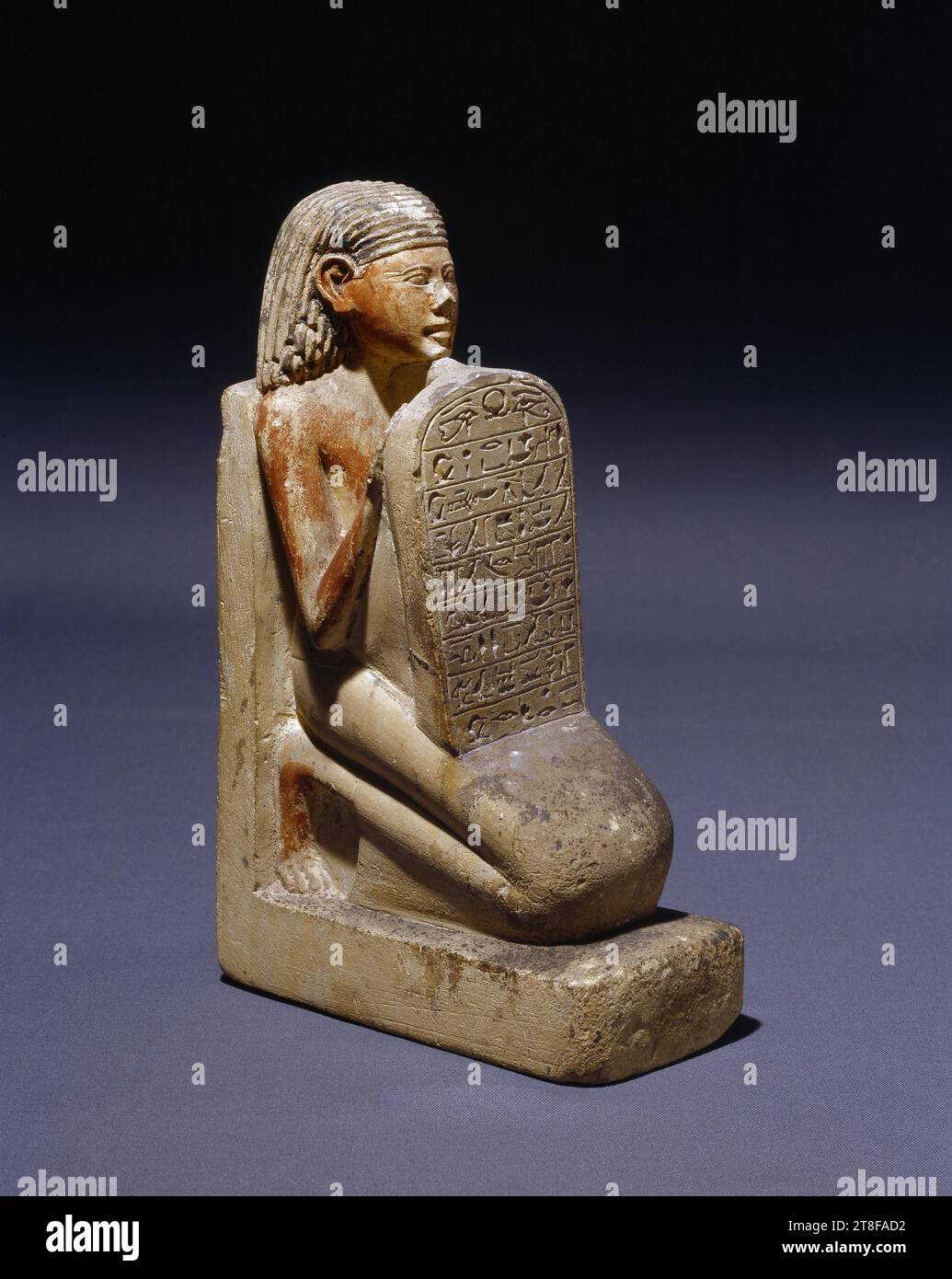 Statuette eines knienden Mannes mit einer Stele, 1500 v. Chr. - 1295 v. Chr., Skulptur, Statuette, die Statuette stellt einen knienden Mann mit leicht erhöhtem Gesicht dar. Mit seinen Händen stützt er eine Stele auf seinem Oberschenkel. Auf der Stele ist eine Inschrift zu sehen, die eine Hommage an den Sonnengott Ra ausdrückt. Die Rückseite der Skulptur zeigt eine Formel, die von einem Opfer für die Götter Amon-Ra und Osiris erzählt. Während der 18. Dynastie (ca. 1550-1300 v. Chr.) Stockfoto