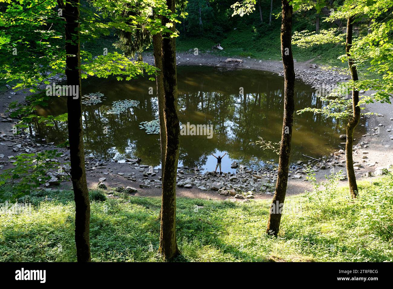 Touristen stehen am Kaali Kraater, einer Gruppe von neun Meteoritenkratern im Dorf Kaali auf der estnischen Insel Saaremaa, Estland Stockfoto