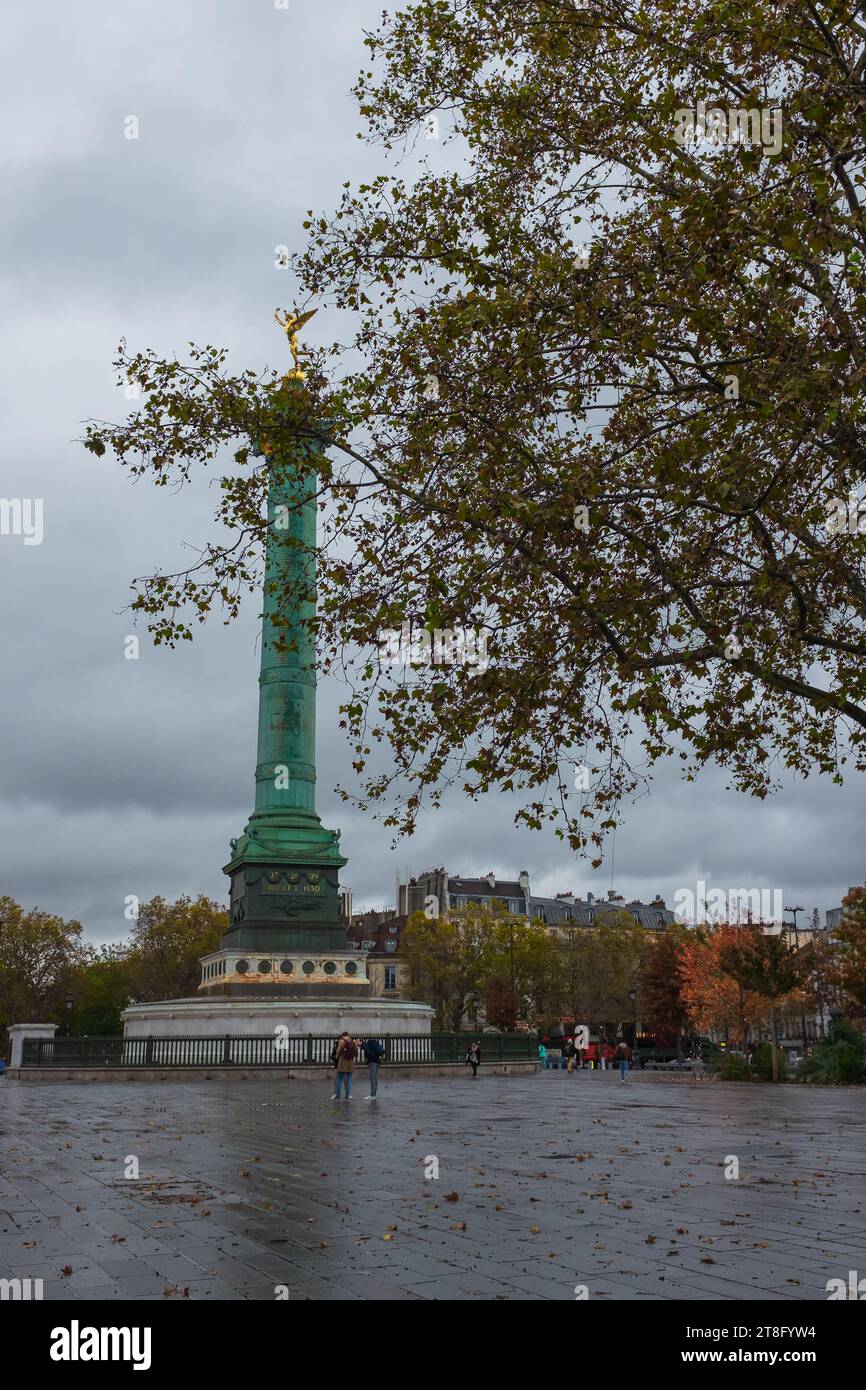 Paris, Frankreich, 2023. Place de la Bastille, die Julisäule und ihre goldene Génie de la Liberté, mit Haussmann-Gebäuden im Hintergrund (vertikal) Stockfoto