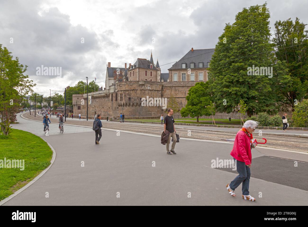 Nantes, Frankreich - 26. Juli 2017: Menschen, die an der Straßenbahnlinie gegenüber der Burg der Herzöge der Bretagne (französisch Château des ducs de Bretagne) spazieren. Stockfoto