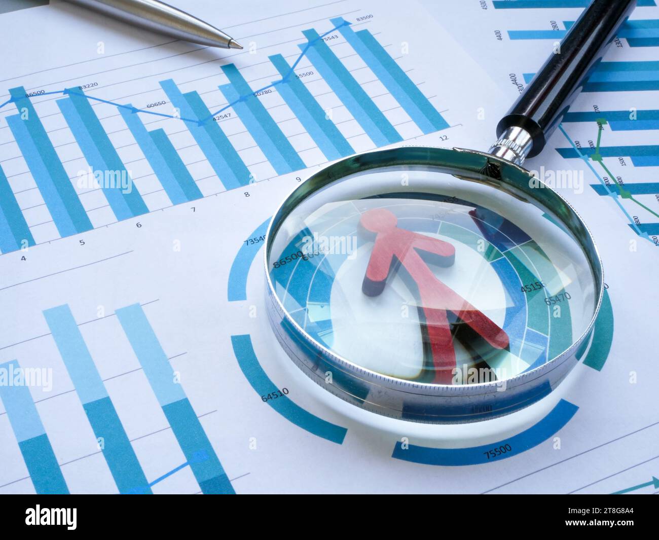 Konzept für Mitarbeiterleistungskennzahlen. Grafiken, Figur und Lupe. Stockfoto